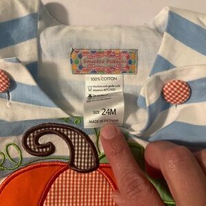 Pumpkin stitched appliqué on a light blue and white dress.